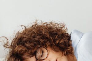 woman in blue shirt sleeping on table with money